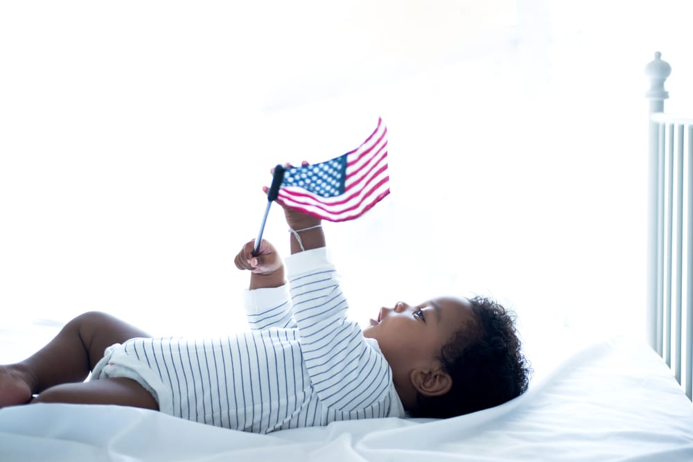 Cute little dark skinned is cute, holding American flag